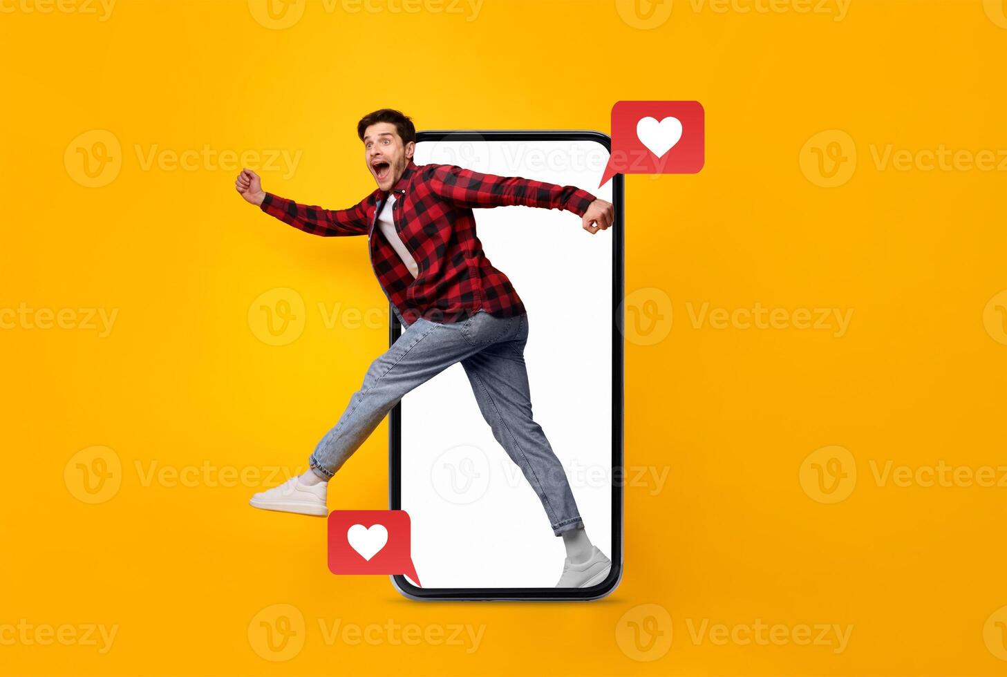 A man joyfully runs out of a smartphone, engaging with social media notifications symbolizing love. The bright yellow background enhances the theme of connection and modern technology. photo
