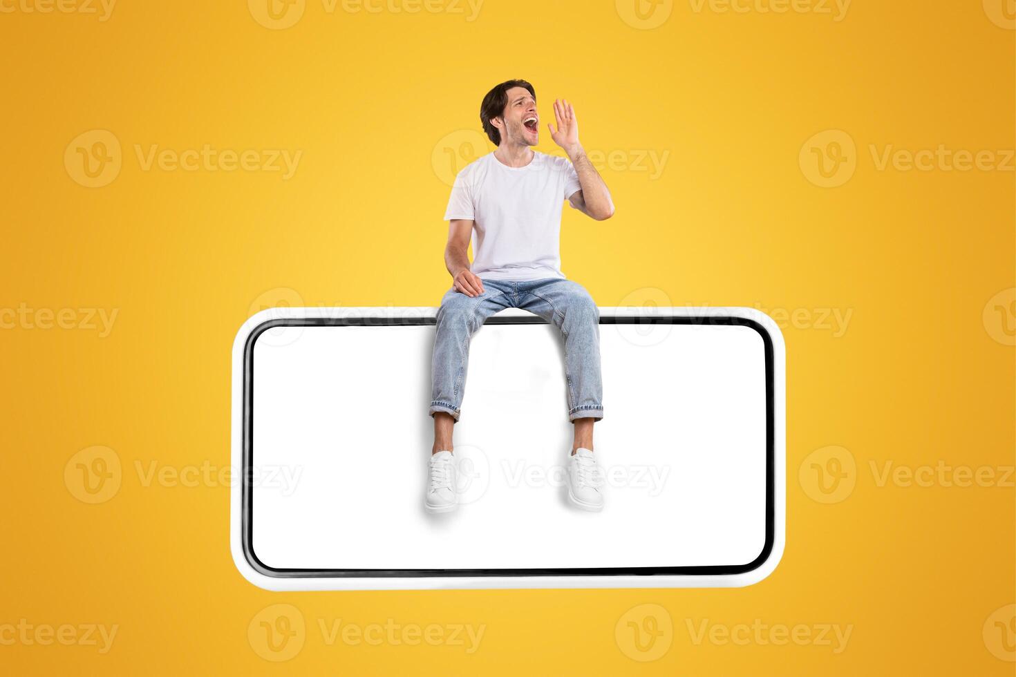 Creative collage of young casual man sitting on smart phone with empty screen making loud announcement at copy space, holding hand near his open mouth, screaming over yellow background, banner photo