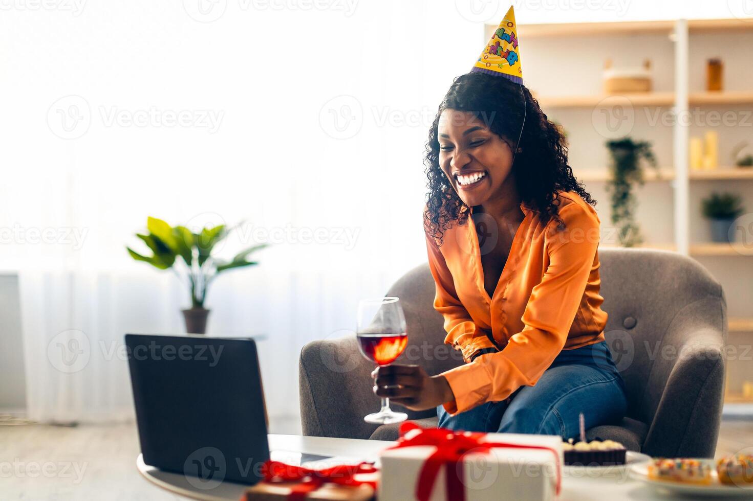 Happy Black Lady Celebrating Birthday Having Remote Online Party Via Call On Laptop, Toasting And Clinking Glasses With Computer Webcam At Home. Distance Holiday Celebration photo