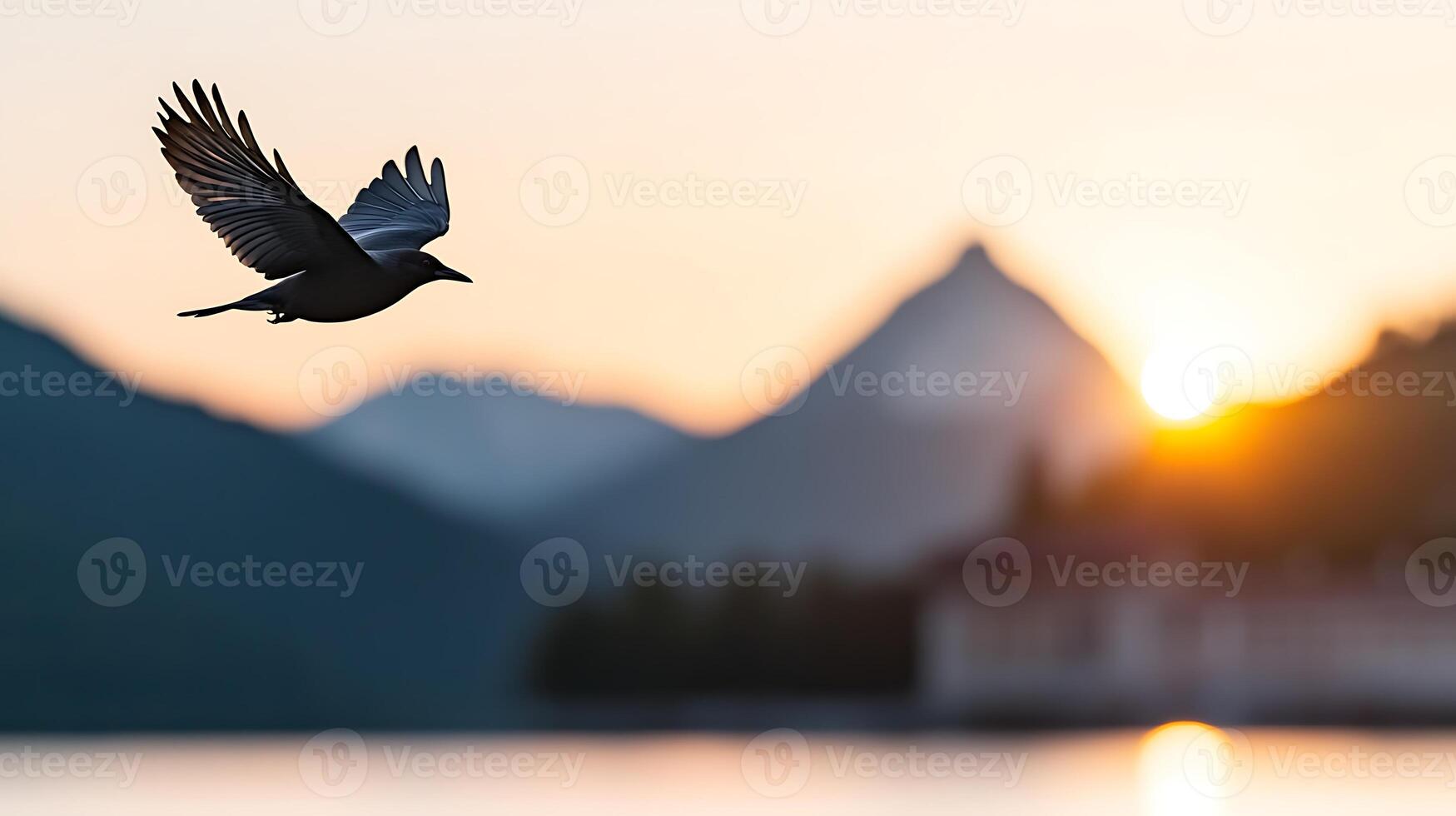 A bird soaring gracefully over a serene lake at sunrise, with mountains in the background photo