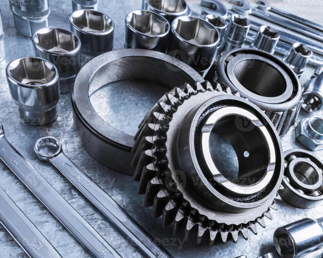 Close-up view of various metal tools and mechanical parts arranged on workbench at a workshop during afternoon photo