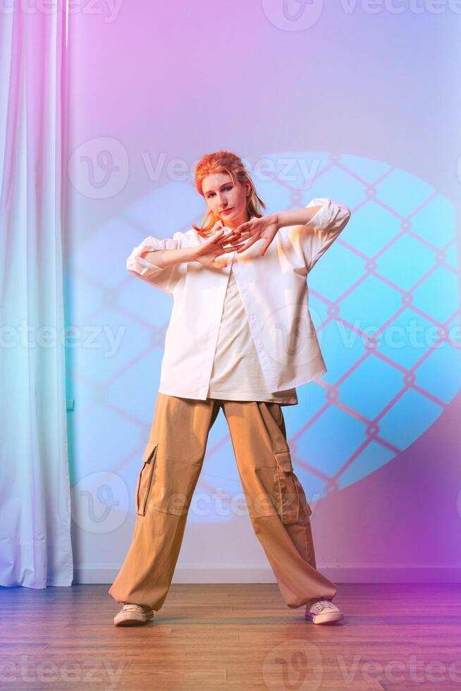 Female dancer performs a contemporary routine in a colorful studio setting with geometric projections photo