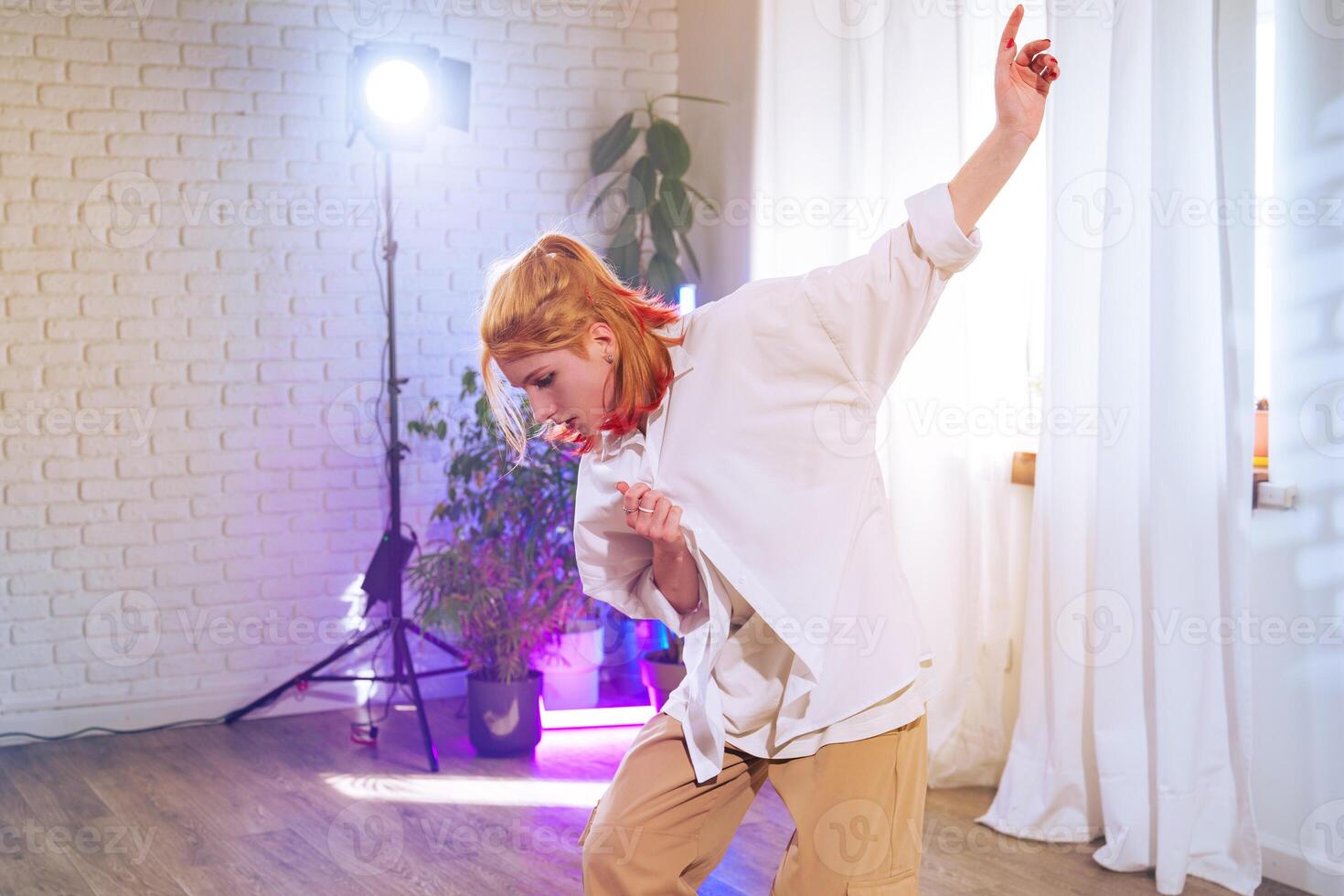 Dance performance by a young woman in a bright studio with natural light and colorful ambiance photo