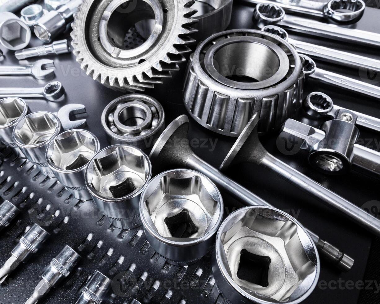 Collection of metal tools arranged neatly on a workbench in a mechanical workshop during daylight hours photo