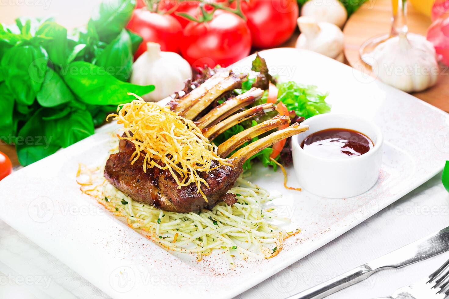 Elegant dish featuring grilled lamb chops served with greens and sauce at a fine dining establishment photo