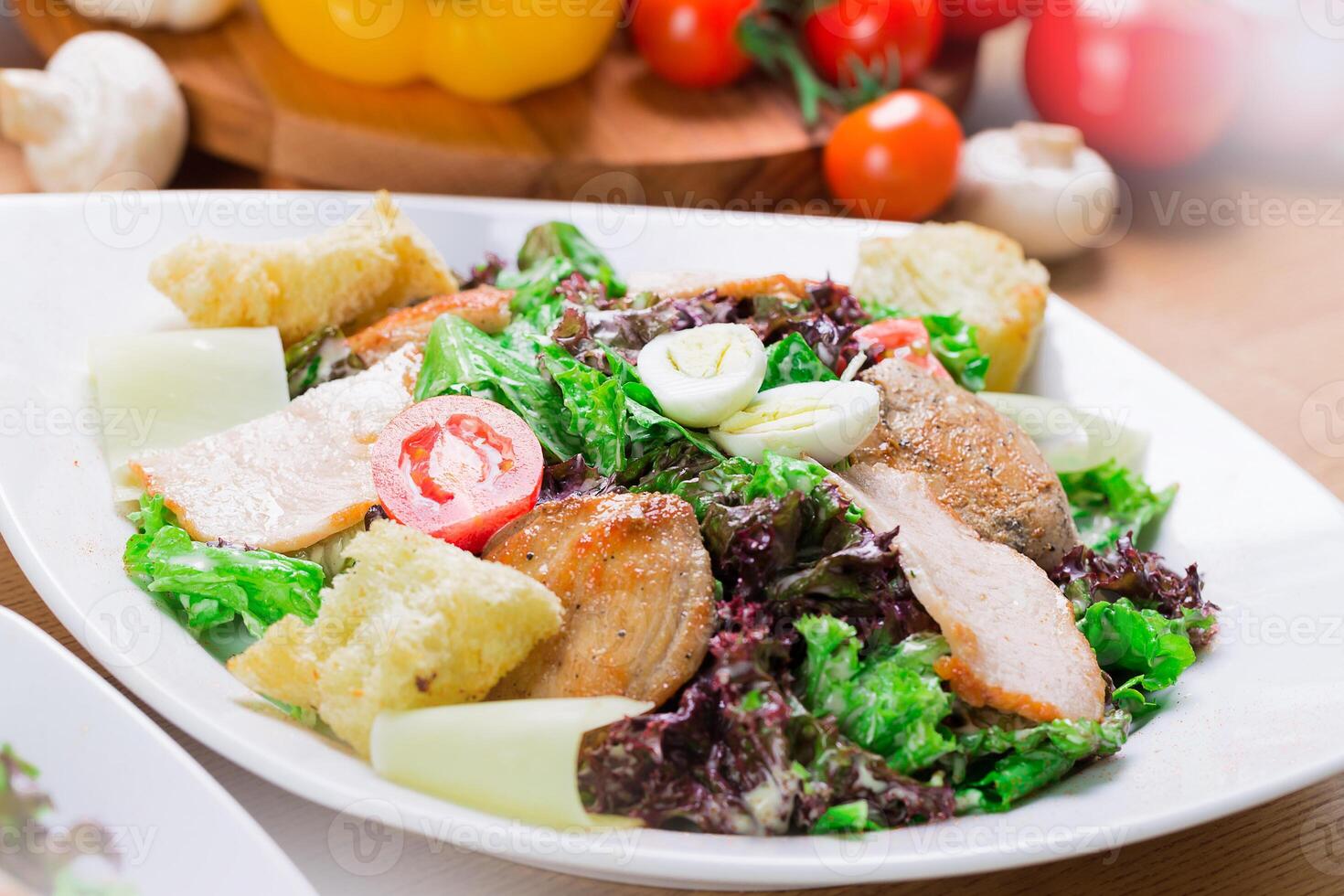 Fresh chicken salad served with vegetables and croutons in a cozy dining setting photo