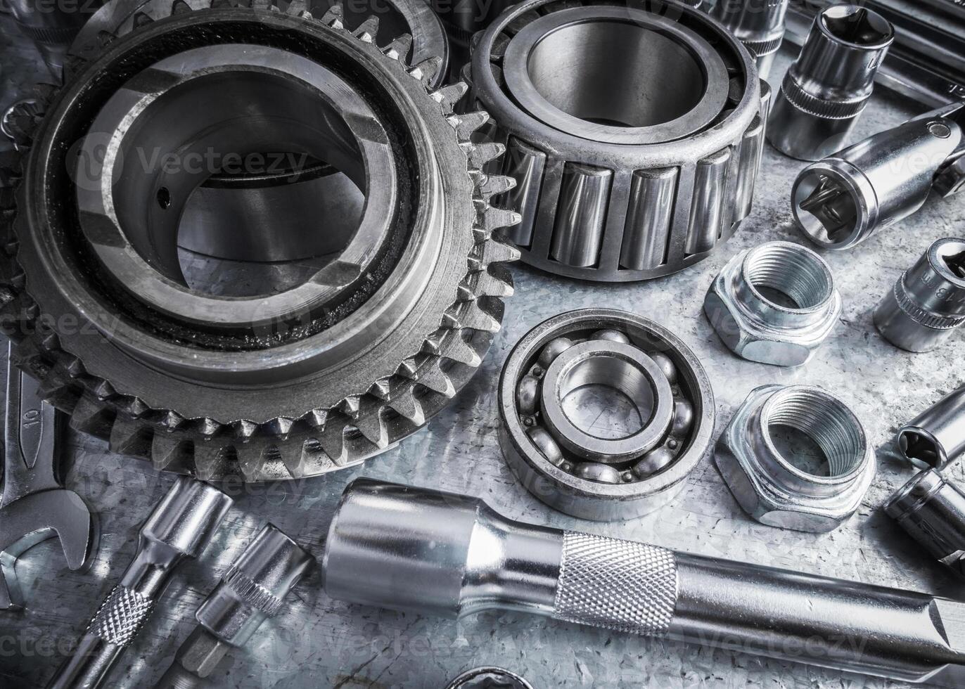 Collection of various mechanical tools and components arranged on a workbench in a garage setting photo