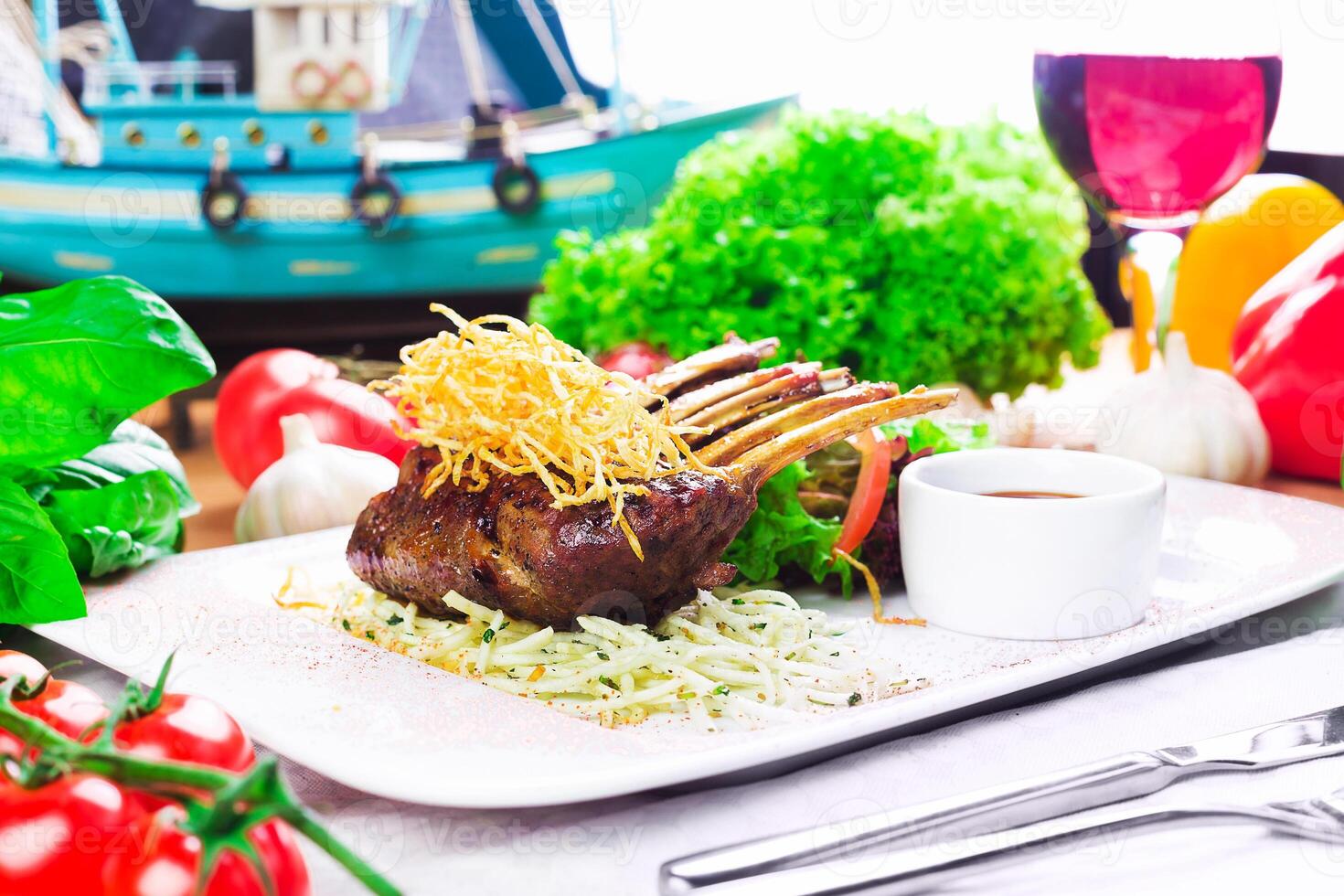 Delicious lamb chops served on a platter with fresh vegetables and a scenic maritime backdrop photo