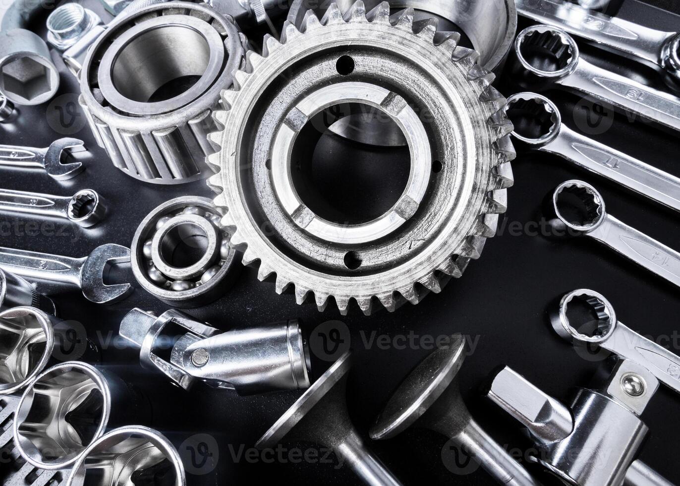 Collection of metallic tools and mechanical components arranged on a black surface showcasing craftsmanship and precision photo