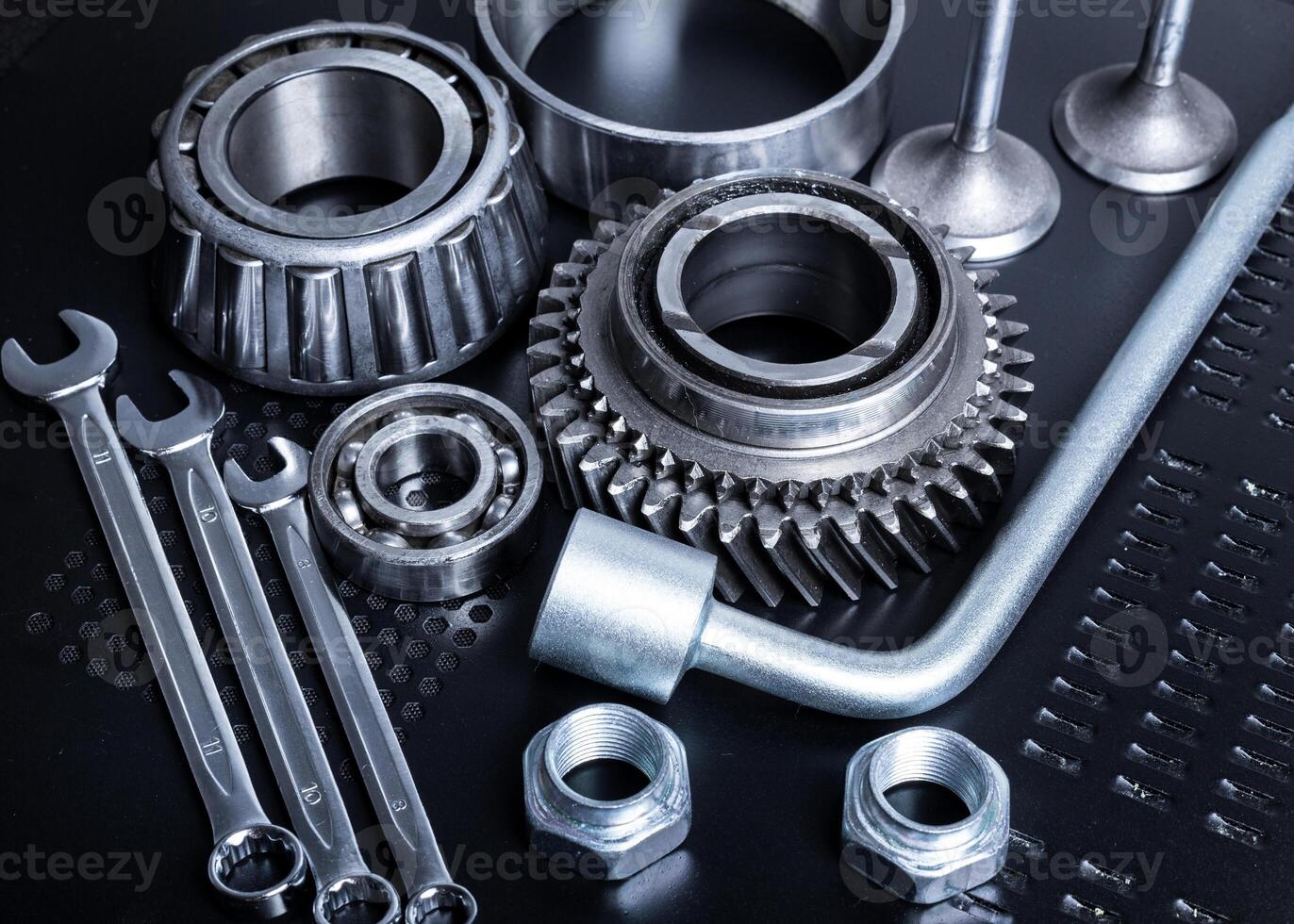 Collection of mechanical tools and parts arranged on a dark surface showcasing craftsmanship and precision tools for automotive work photo