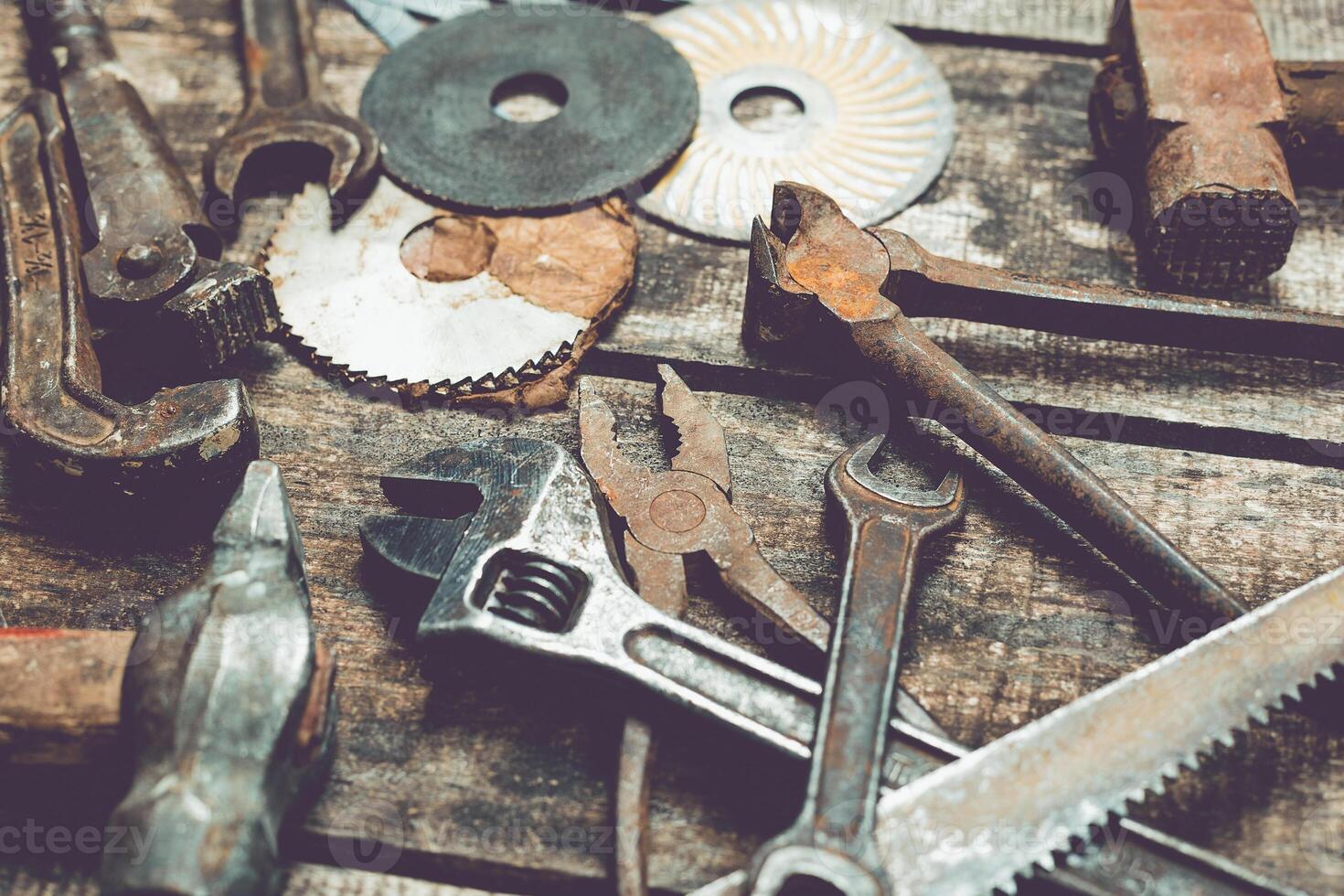 Collection of vintage hand tools and hardware components on a rustic wooden surface in a workshop setting photo