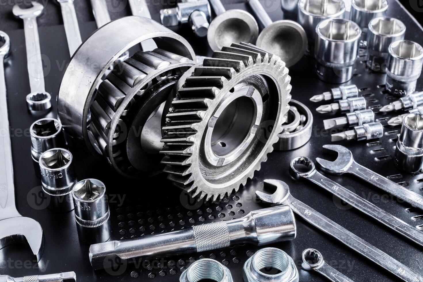Various metallic tools and mechanical parts arranged on a dark surface showcasing craftsmanship and engineering precision photo