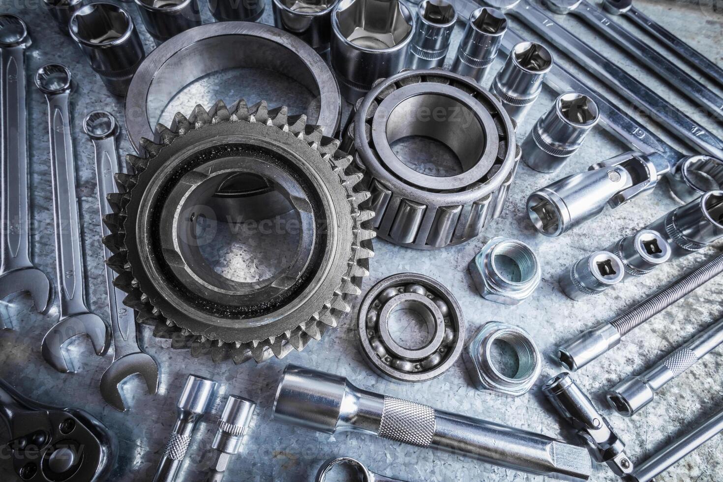 Metal tools and parts arranged on a workbench for mechanical repairs in a garage setting photo