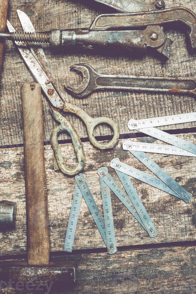 Vintage tools and measuring instruments arranged on a rustic wooden surface in a workshop environment photo