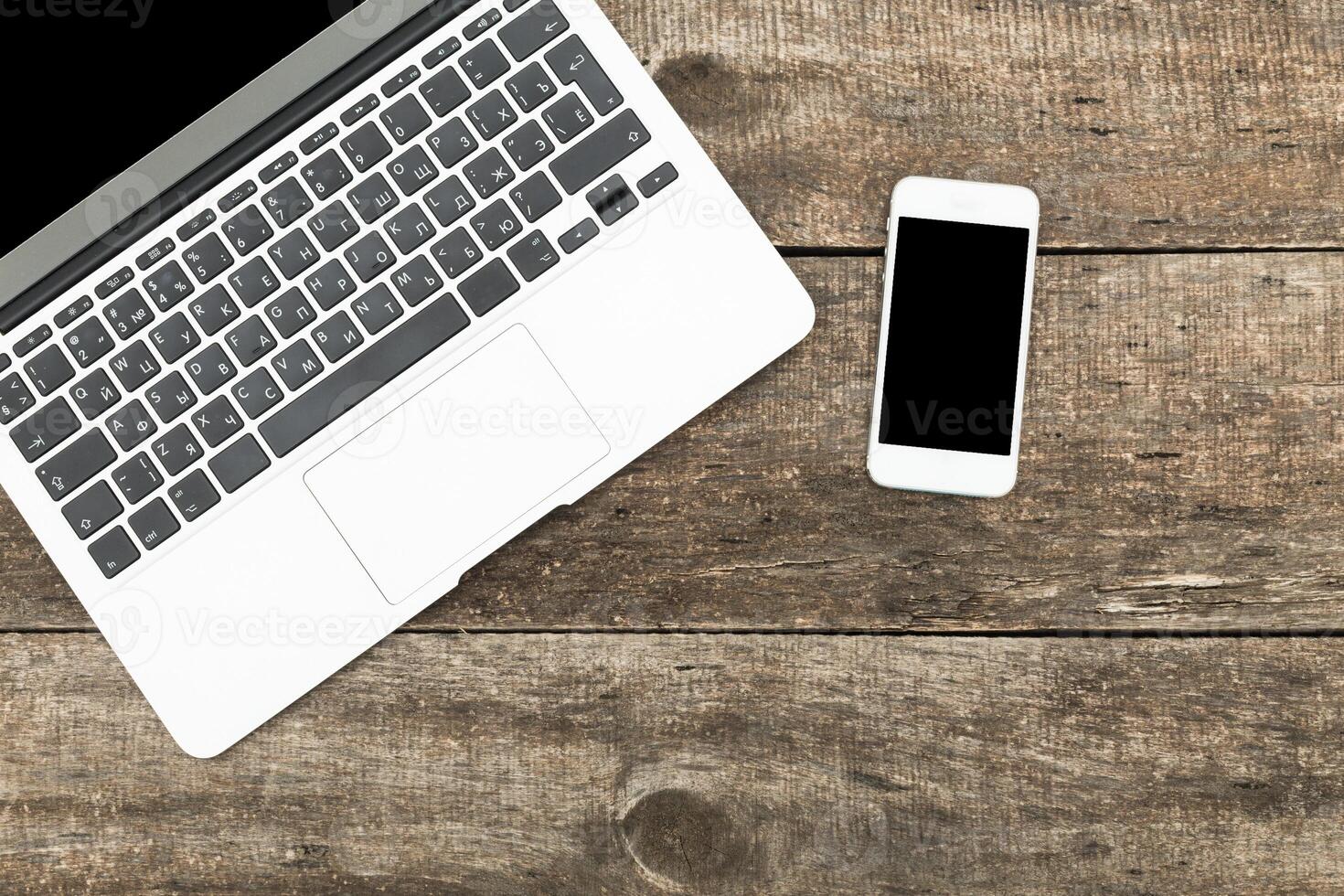 Workspace with laptop and smartphone on rustic wooden table photo