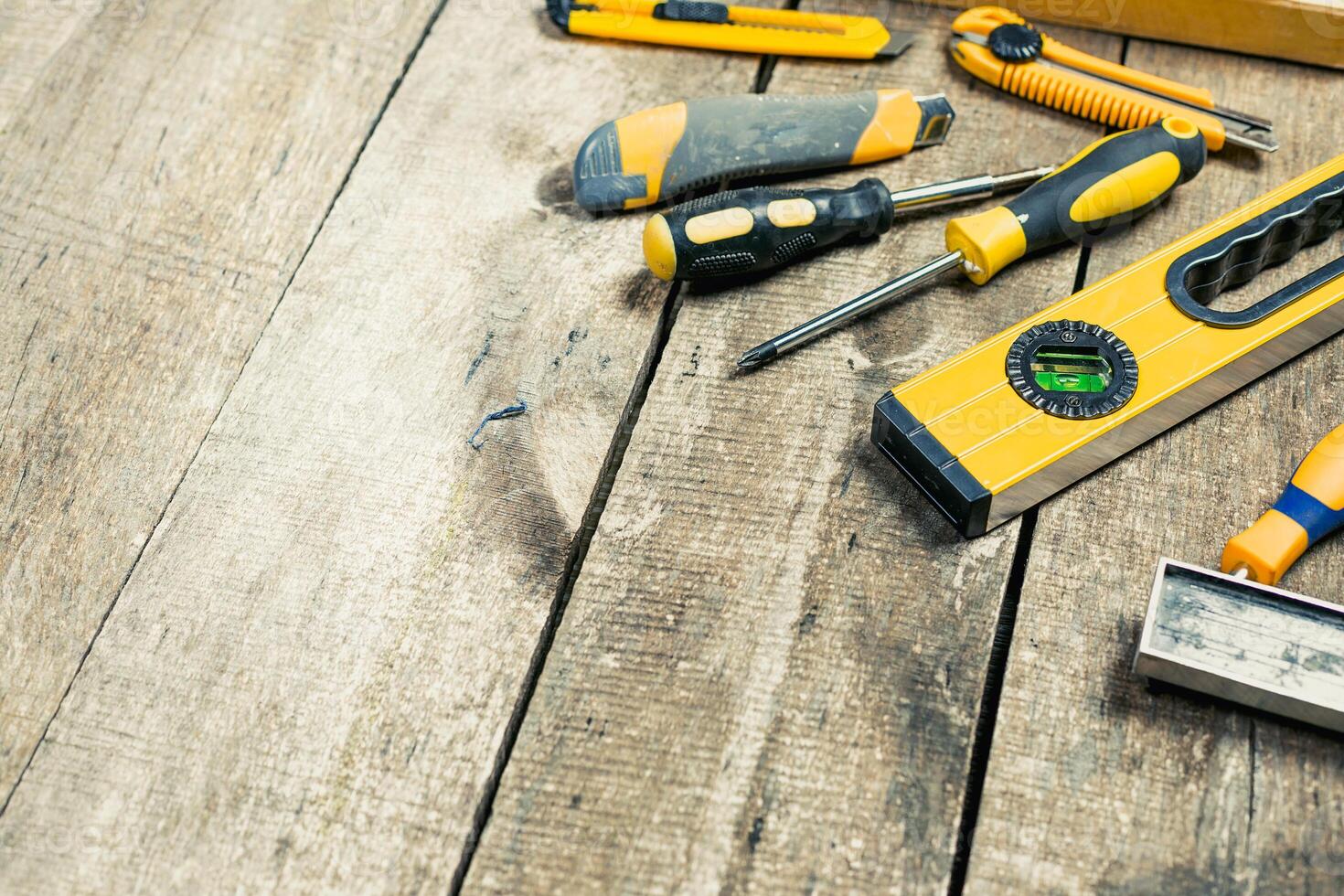 Home improvement tools are scattered on a wooden workbench ready for a project during a sunny afternoon photo