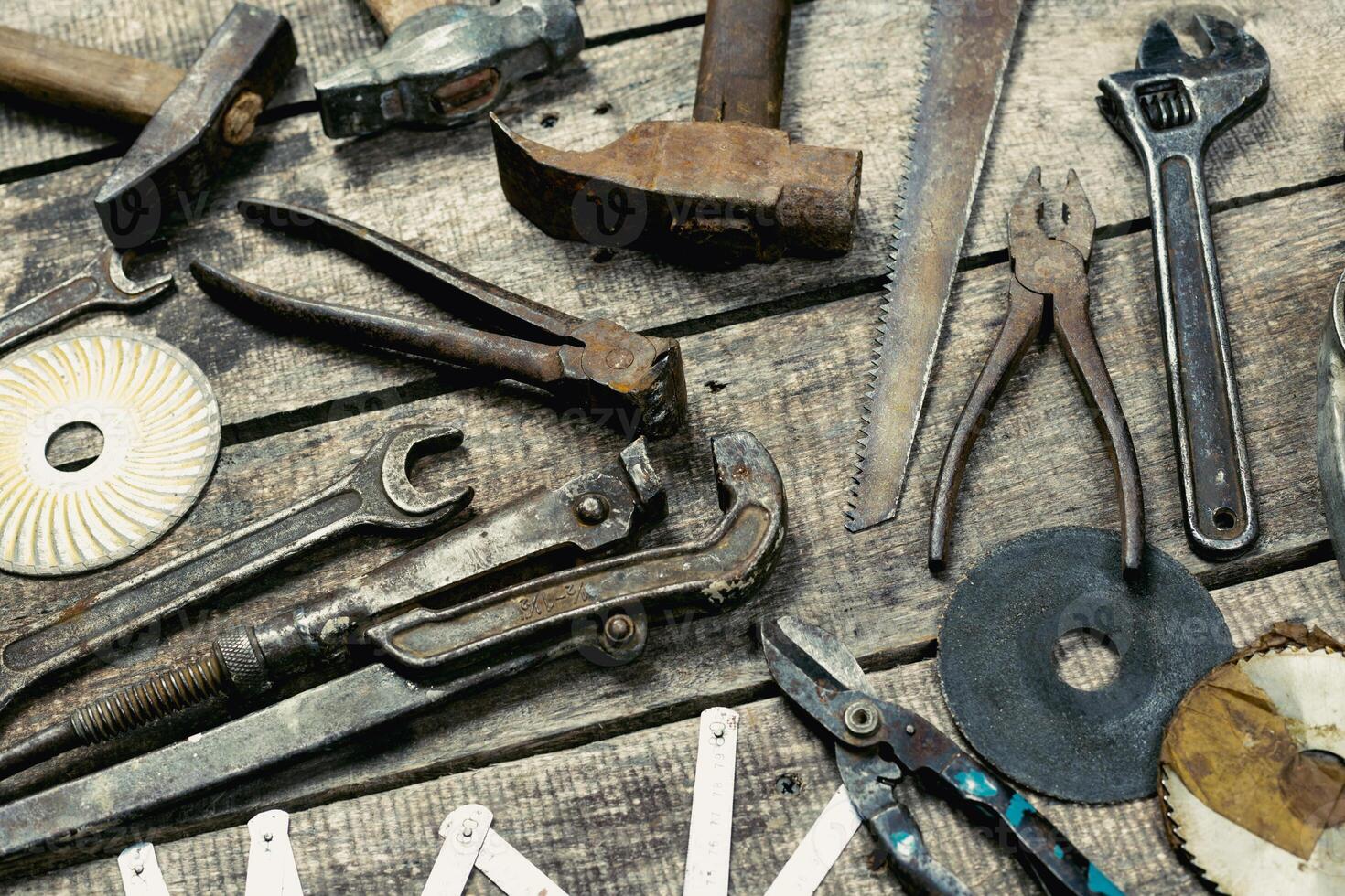 Assorted hand tools displayed on rustic wooden surface in workshop setting during daylight hours photo