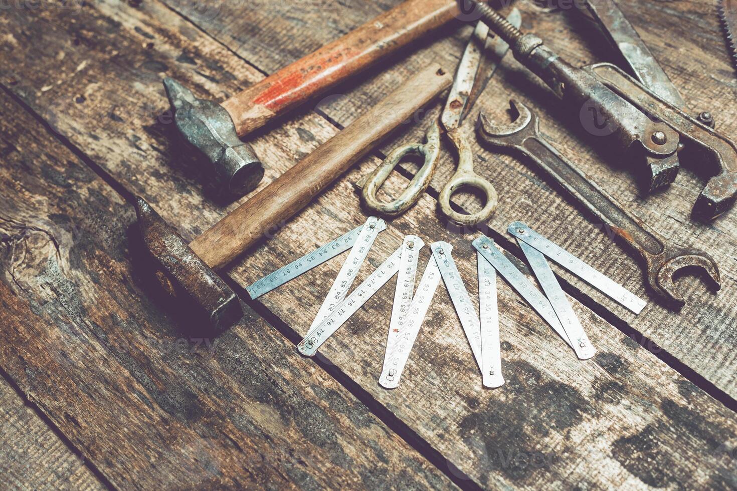 Collection of hand tools arranged on a rustic wooden surface, highlighting craftsmanship and repair work photo