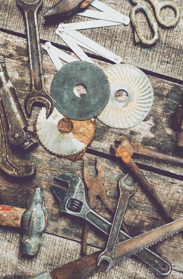 Collection of vintage hand tools and materials arranged on a rustic wooden workbench in a workshop setting photo