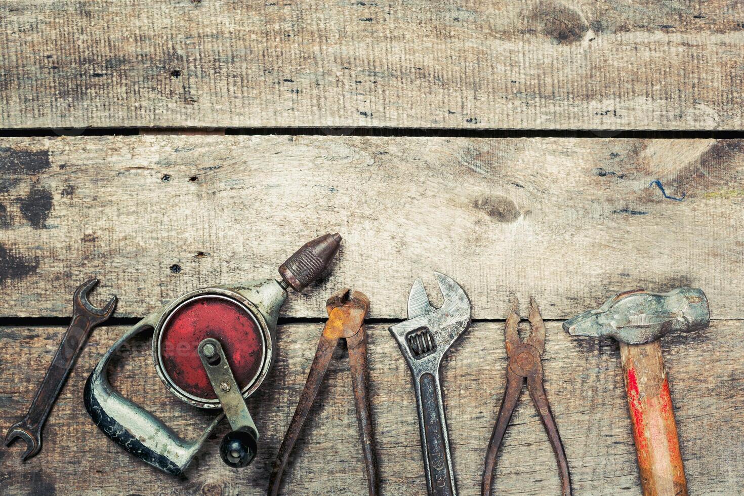 Vintage assortment of hand tools arranged on a rustic wooden surface showcasing their unique features photo
