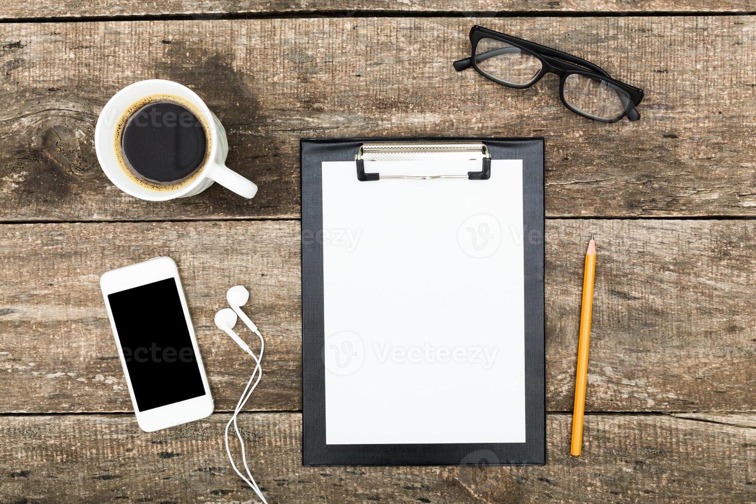 Workspace setup with coffee, notepad, smartphone, and glasses for productive planning and creativity photo