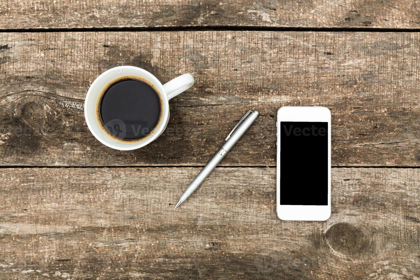 Coffee and smartphone on a rustic wooden table, peaceful morning setup for work or relaxation photo