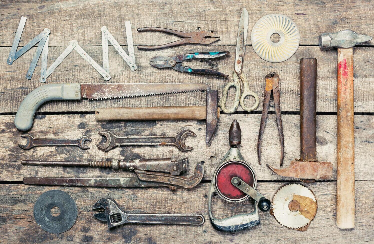 Collection of various hand tools arranged neatly on a rustic wooden surface for DIY enthusiasts and craftsmen photo