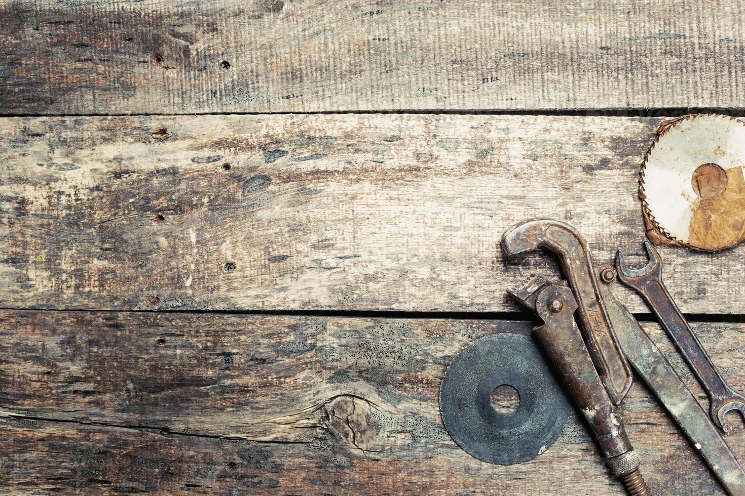 Rustic wooden surface with vintage tools scattered across, perfect for a DIY project setting photo