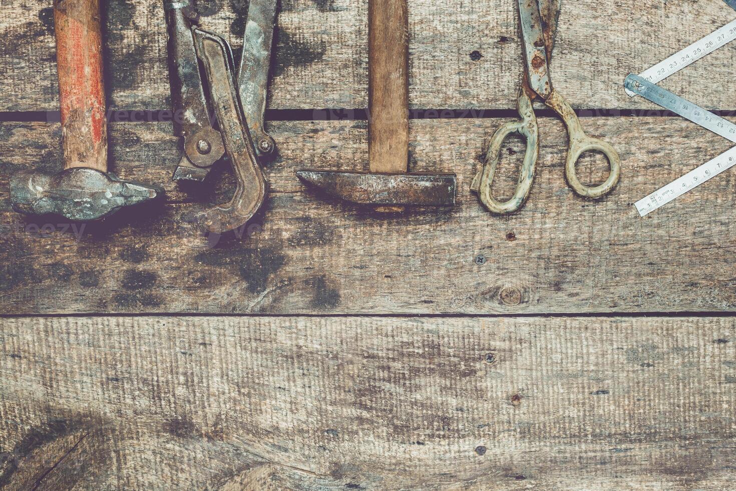 Assorted vintage tools arranged on weathered wooden surface showcasing craftsmanship and history photo