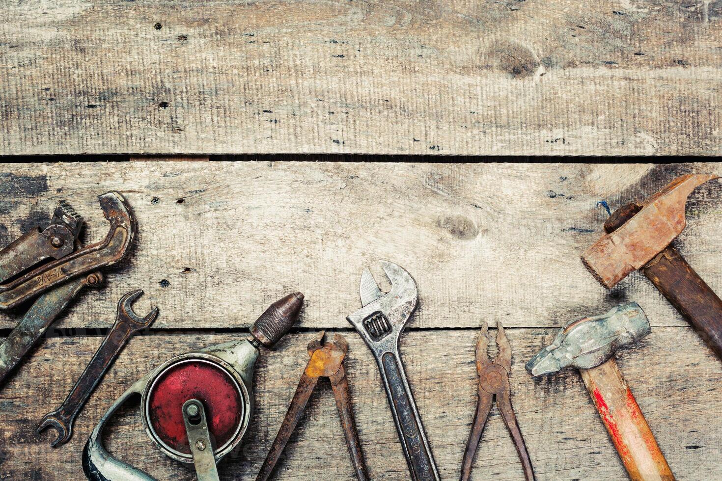 Hand tools arranged on a rustic wooden surface showcasing various shapes and sizes for home improvement tasks photo