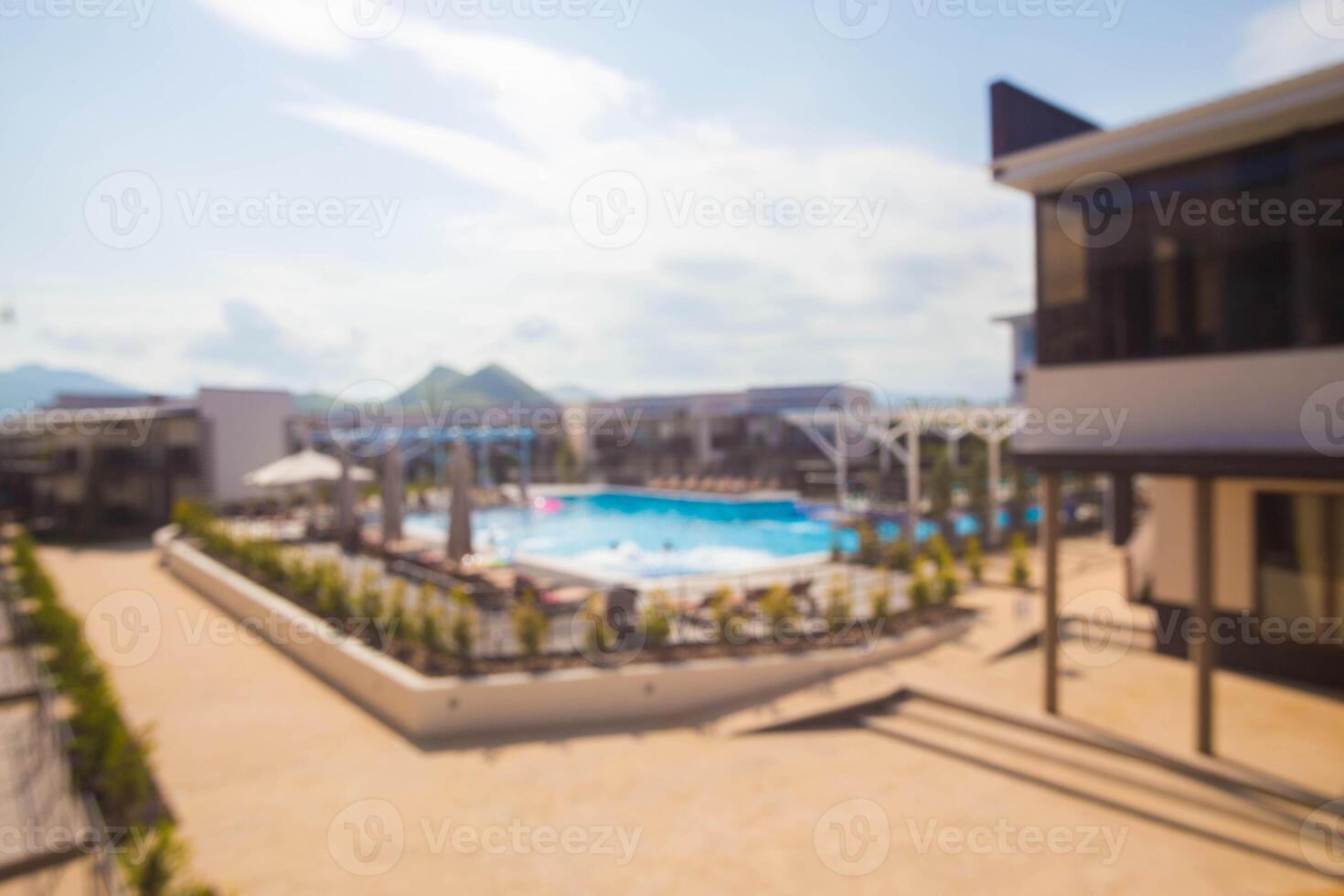 Relaxing day by the pool at a modern resort in a sunny location surrounded by mountains photo
