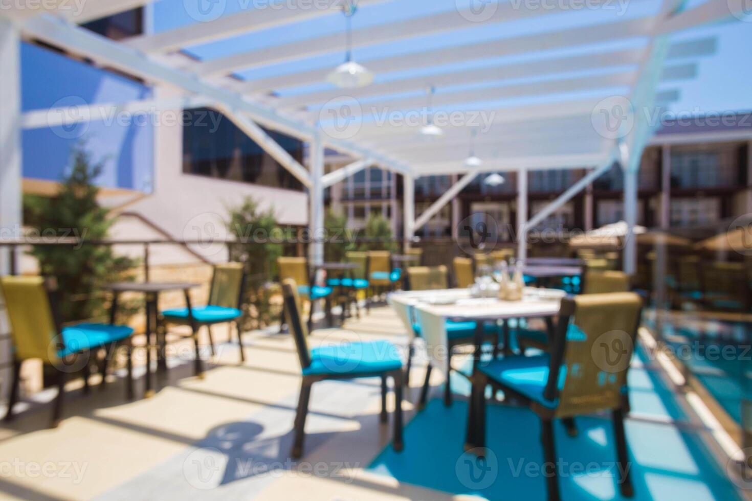 Outdoor dining area with vibrant furniture near a pool on a sunny day in a modern setting photo