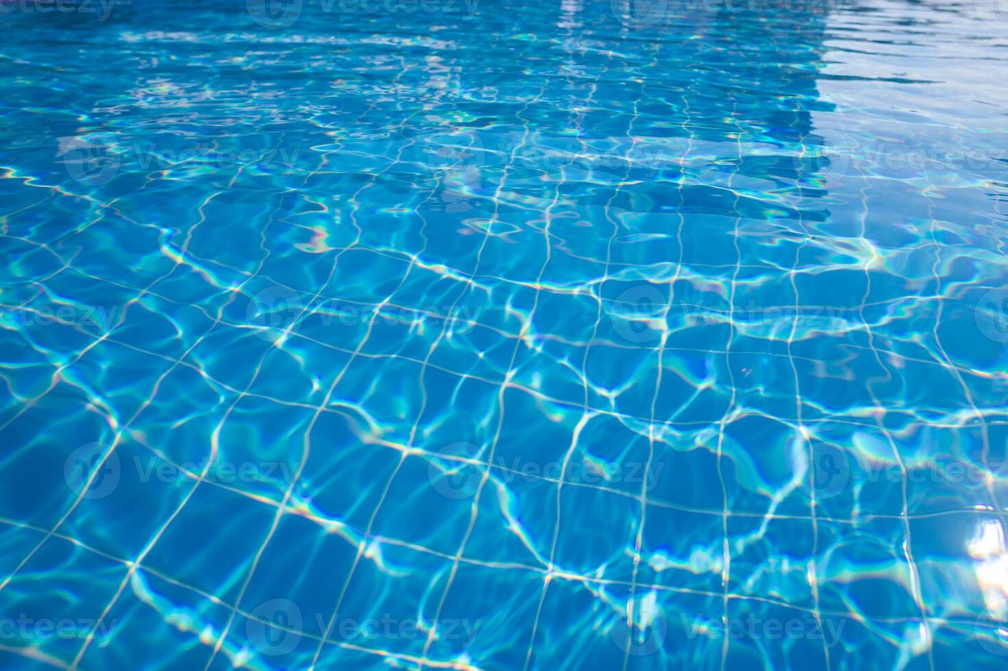Bright blue swimming pool water reflecting sunlight creates a calm and inviting atmosphere in a sunny setting photo