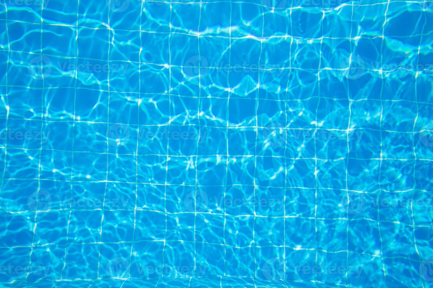 Clear blue water surface with captivating reflections in a swimming pool during a sunny day photo