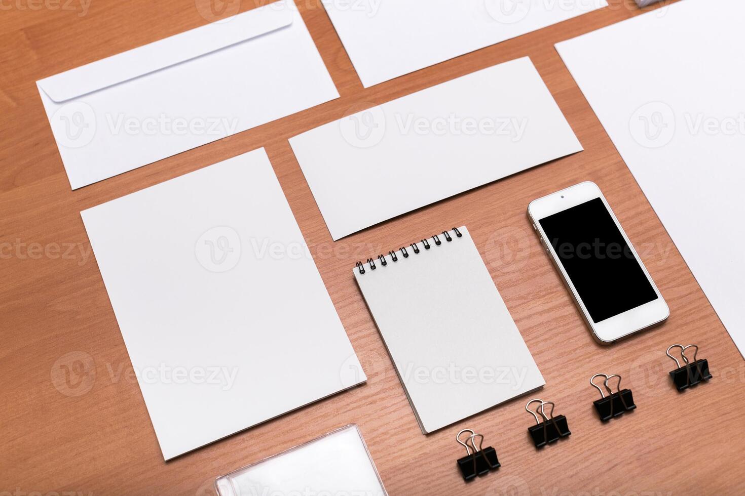 Office workspace organized with stationery items and a smartphone on a wooden table photo
