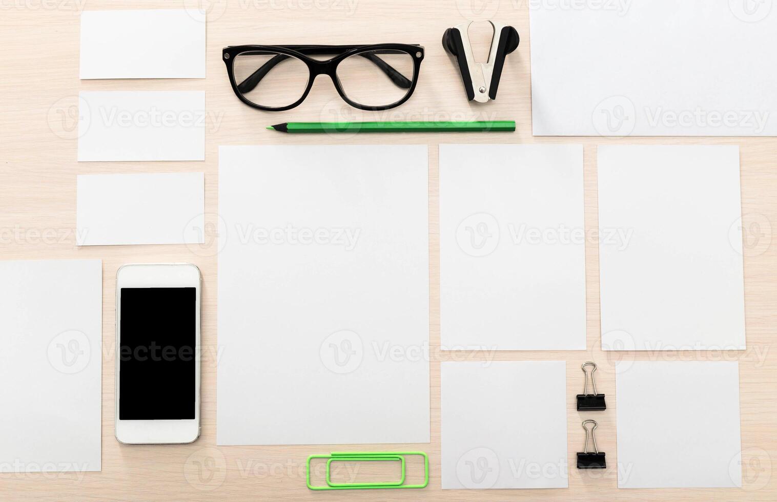 Office workspace with stationery and mobile device on a wooden desk in a well-lit environment ideal for productivity photo