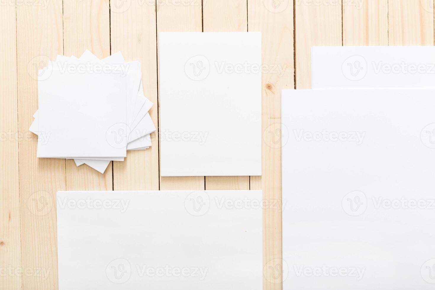 Assorted sheets of blank paper arranged on a wooden surface for creative projects photo