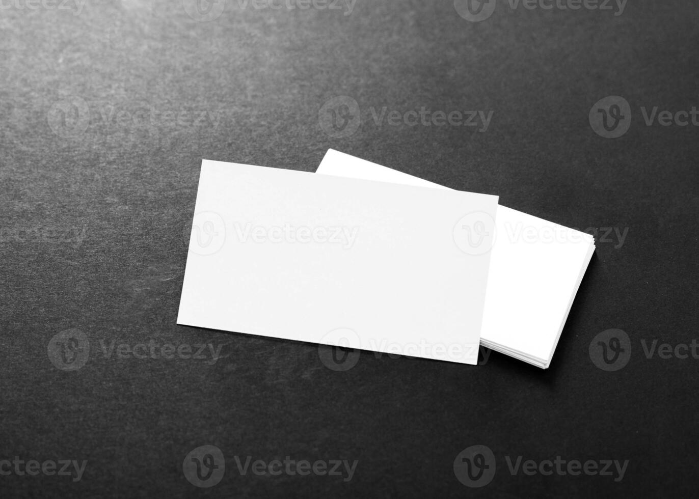 Blank business cards stacked neatly on a dark background creating a minimalistic and professional appearance photo