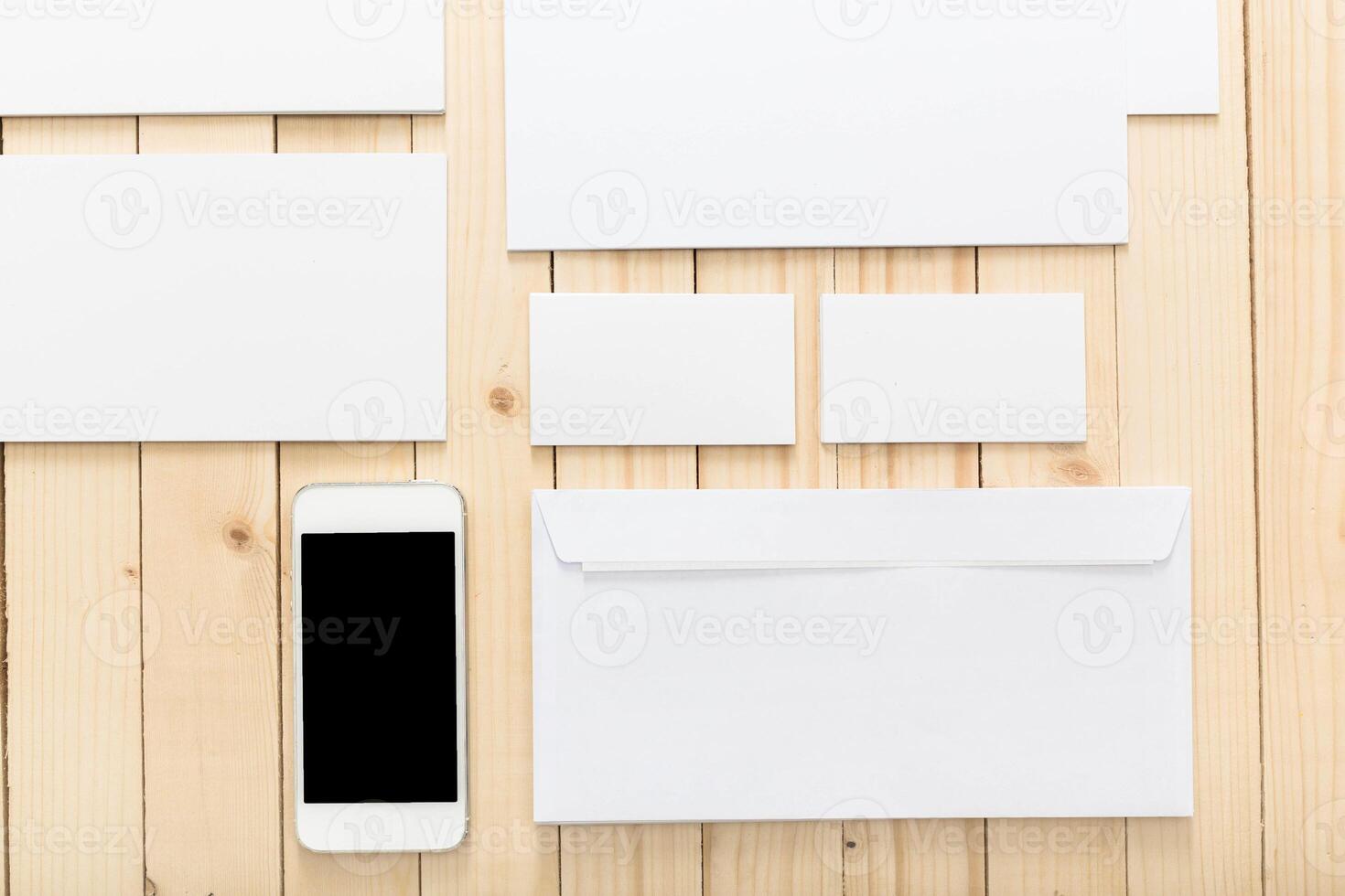 Stylish arrangement of blank stationery and a smartphone on a wooden surface for branding and design purposes photo