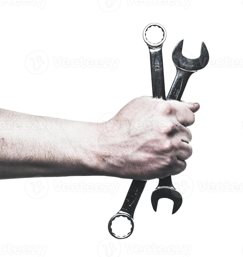 Skilled hands hold wrenches ready for mechanical maintenance and repair tasks in a workshop setting photo