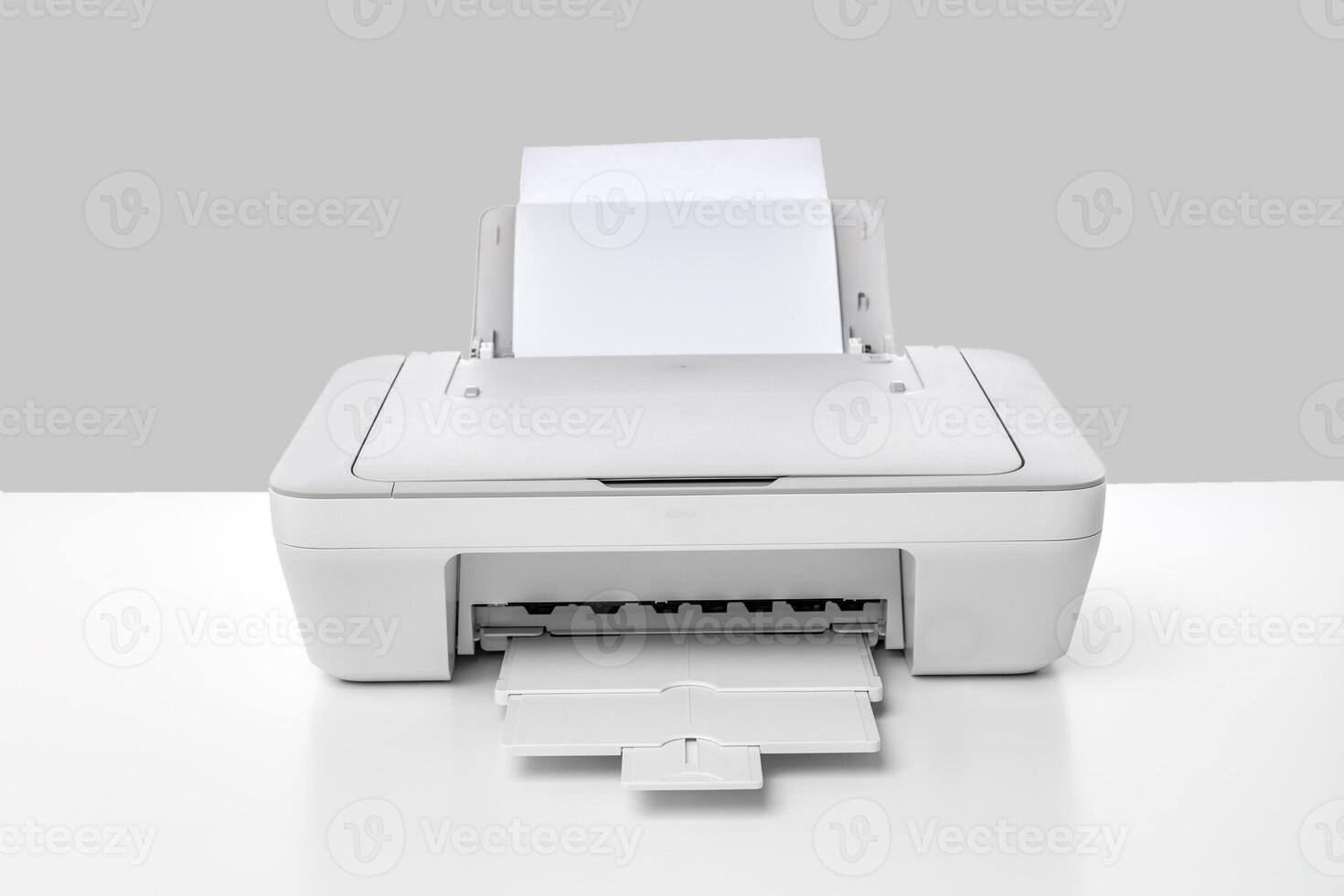 Modern desktop printer with printed paper ready for collection on a clean table surface photo