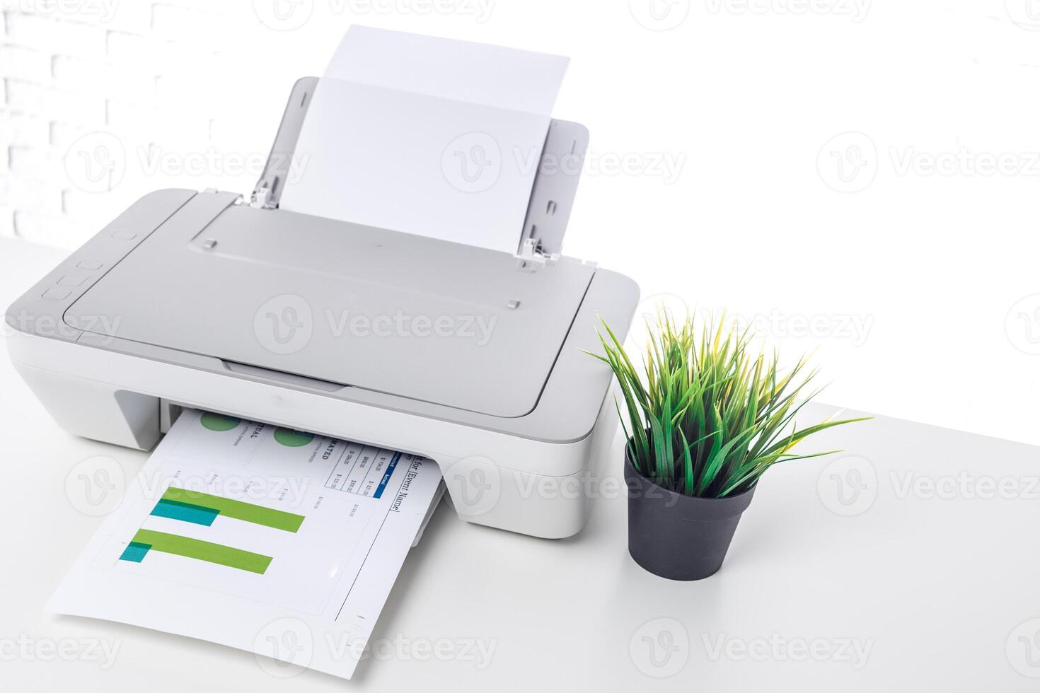 Printer at work in a bright office space with fresh greenery and colorful documents being printed during daylight hours photo