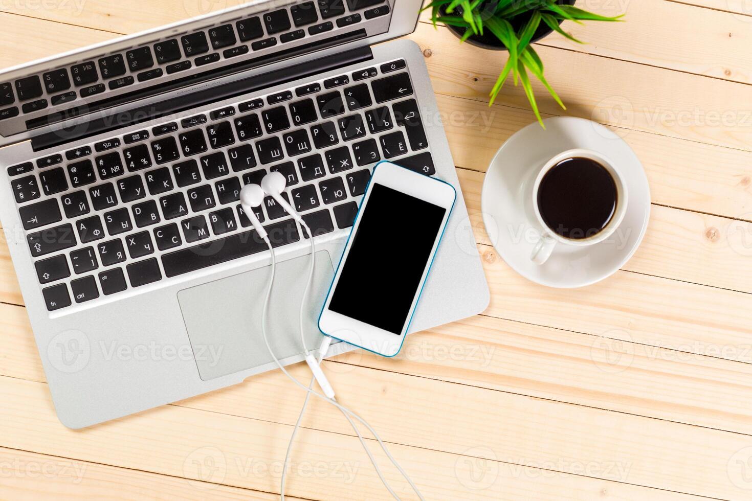 Relaxing workspace features coffee, smartphone, and laptop on a wooden table photo