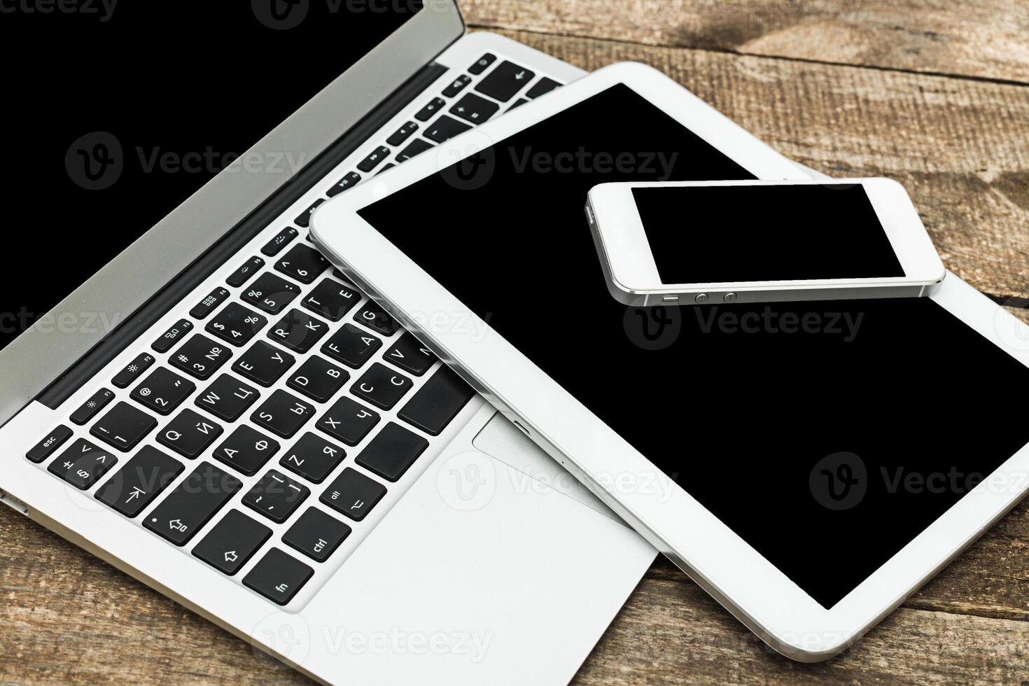 Digital devices arranged on wooden surface showcasing technology and connectivity in a modern workspace environment photo