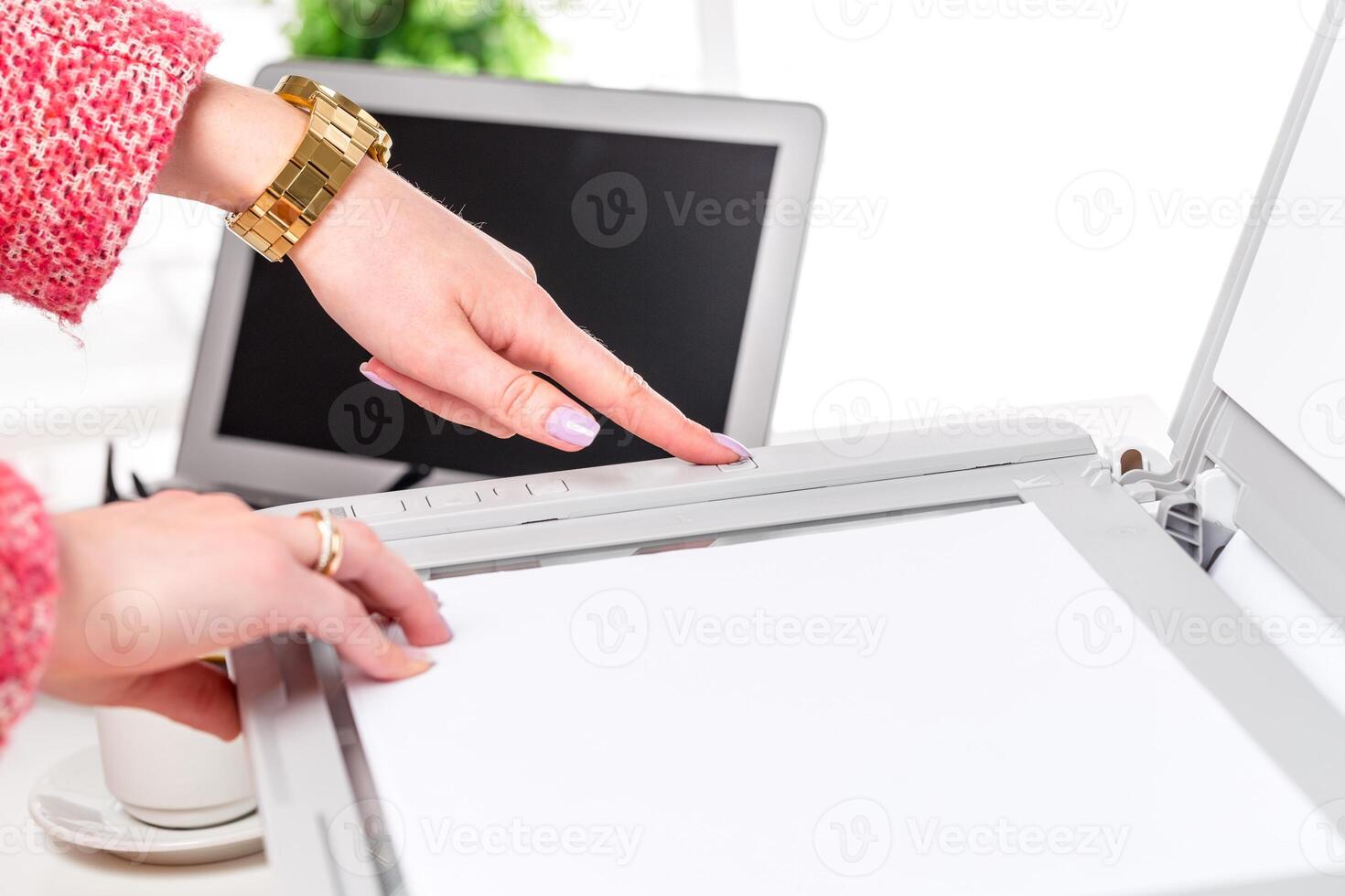 Hands pressing a button on a scanner while preparing documents in a modern office setting photo