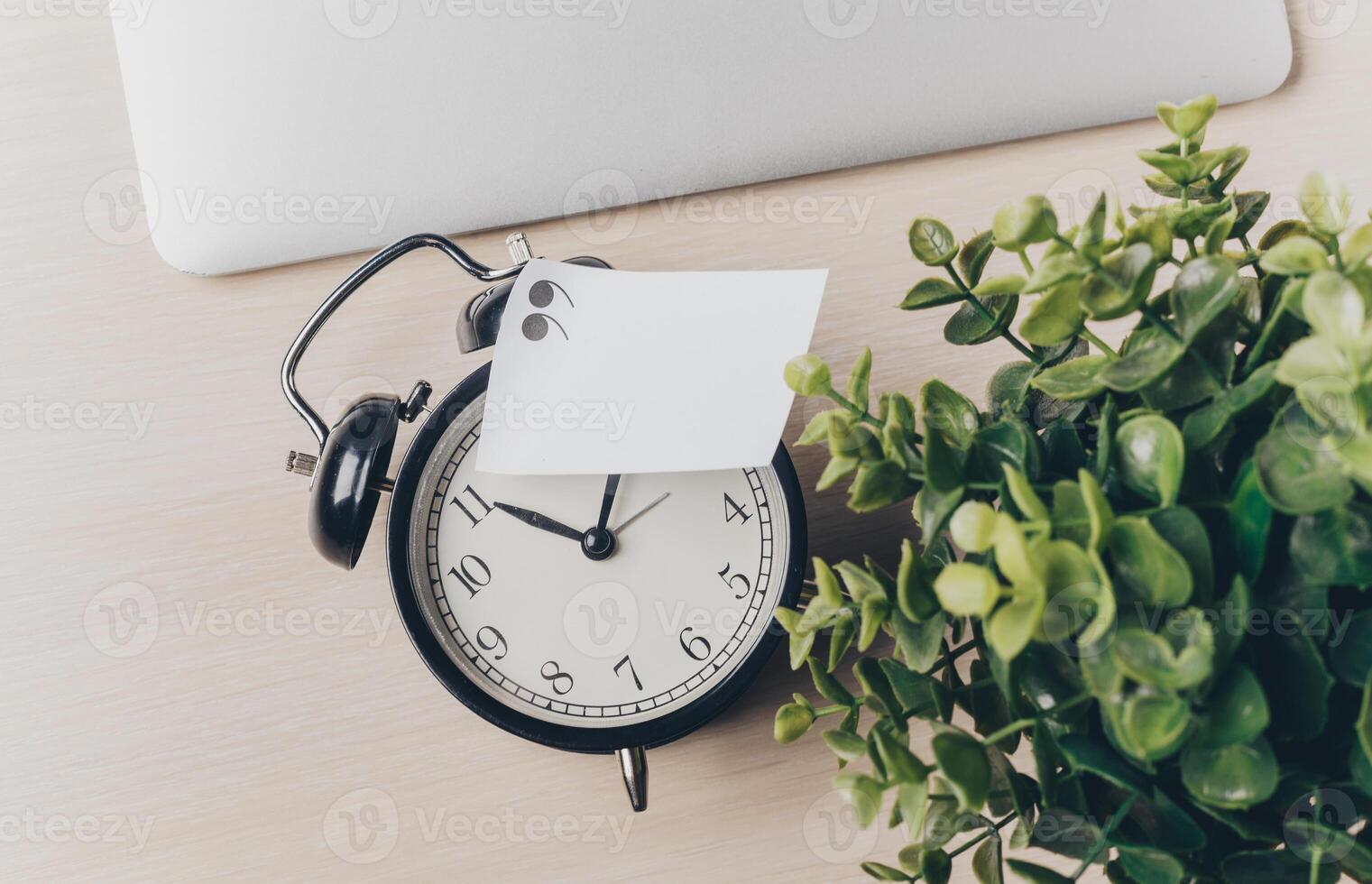 Time management tools on a desk with a clock and a small plant reminding of productivity and organization at work photo