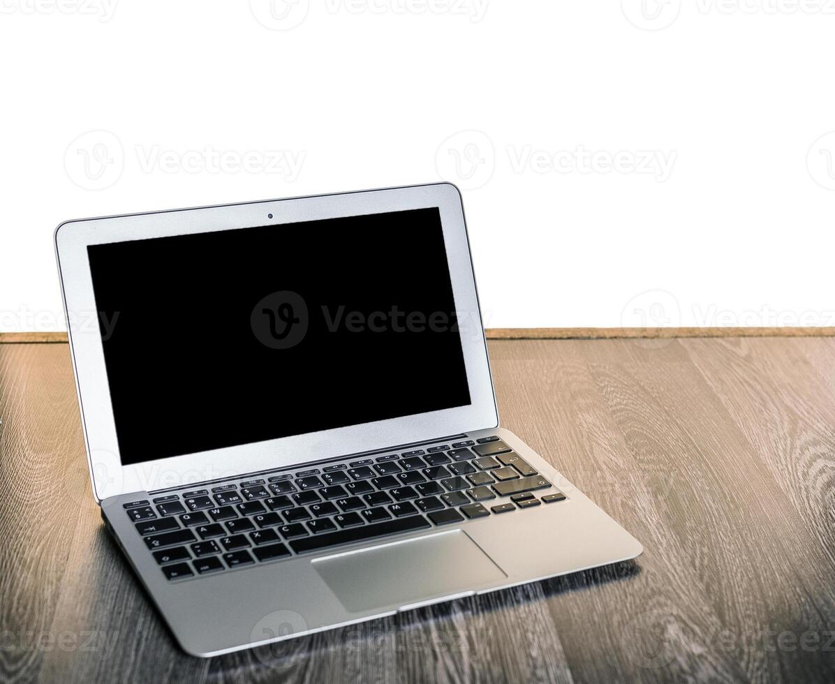 Silver laptop placed on wooden surface with blank screen, suggesting potential for productivity or creativity photo