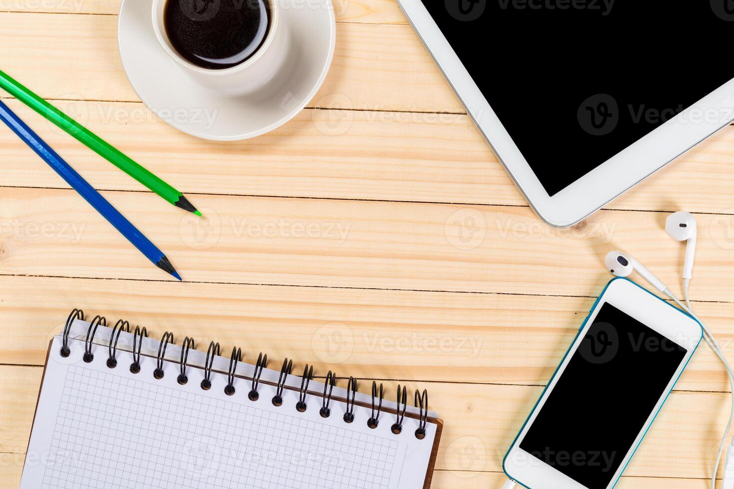 Workstation setup with notebook, electronic devices, and coffee on wooden table photo