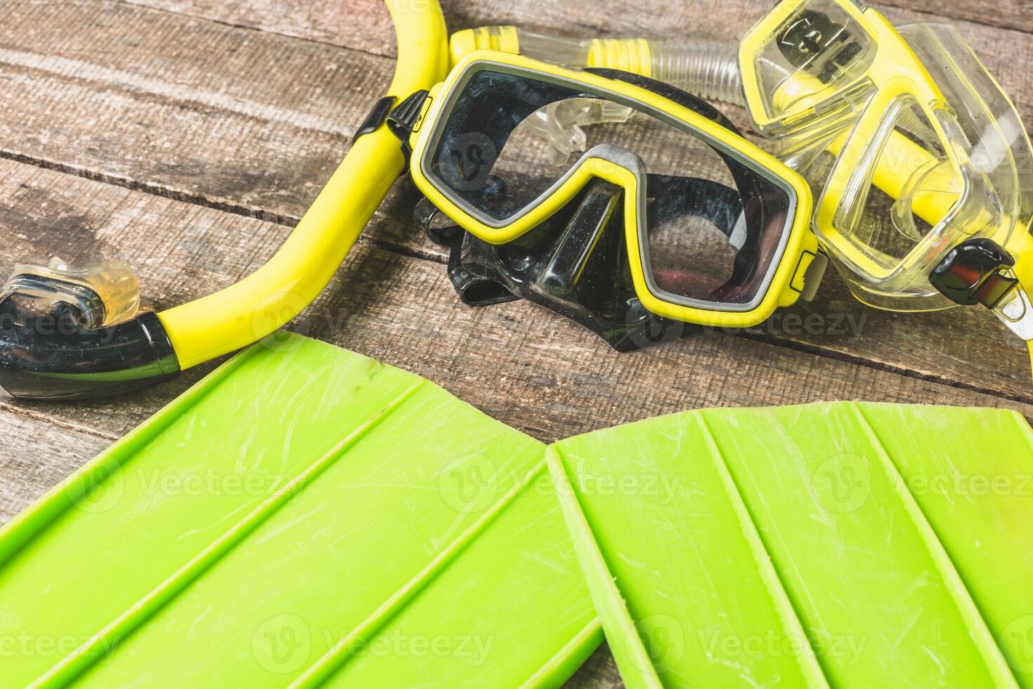 Diving equipment laid out on wooden surface, showcasing colorful snorkel mask and fins ready for an underwater adventure photo