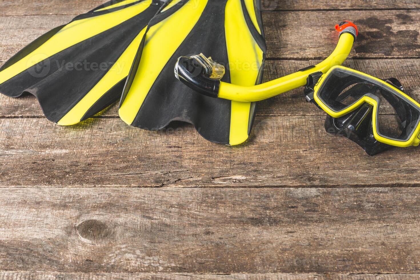 Snorkeling equipment resting on a wooden surface ready for underwater adventure in a tropical location photo